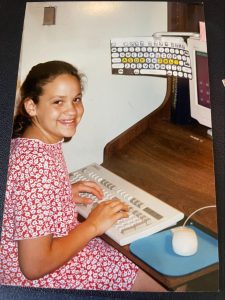 A young Camilla Taylor typing away at her father's office computer.